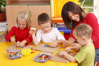 teacher and three preschoolers playing with wooden blocks